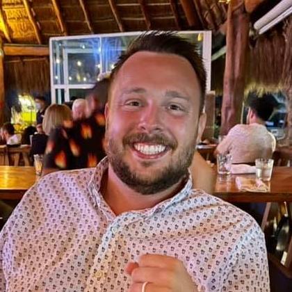 Austin D. Williams at dinner under a palapa roof