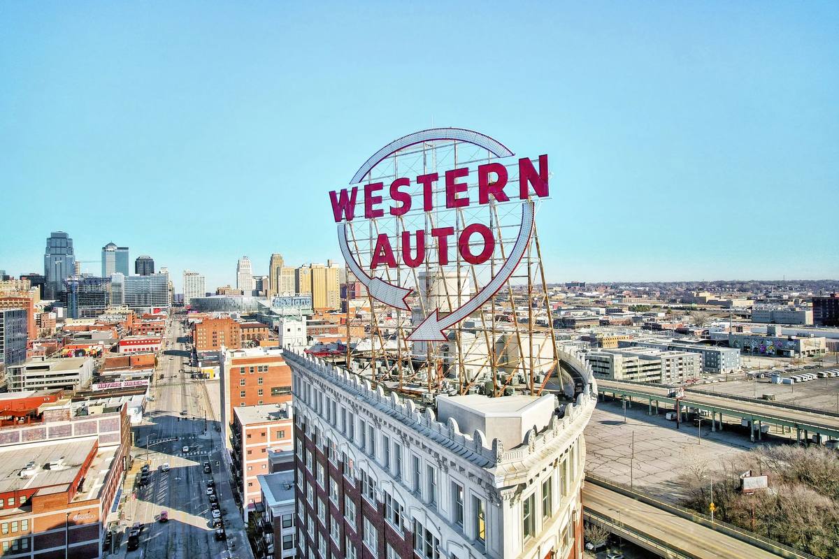 Aerial view of the Western Auto sign in Kansas City's Crossroads with the downtown skyline behind it